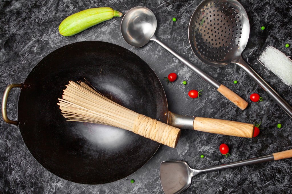 Set of kitchen tools and frying pan on a black textured background. top view. : 3M Gadgets Must-Have Features for Effortless Wok Cooking